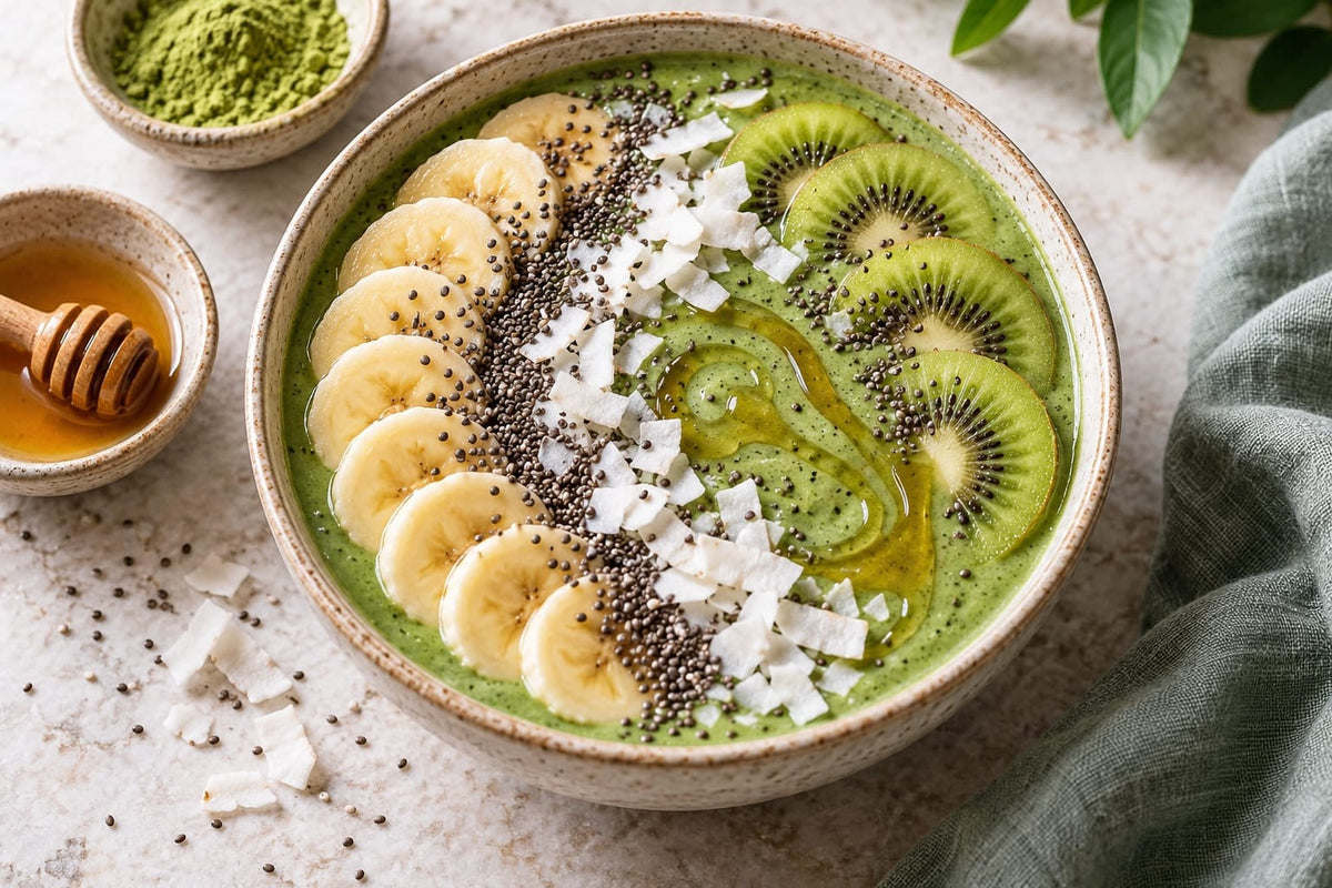 Grüne Smoothie-Bowl mit Bananen- und Kiwischeiben, Chiasamen und Kokosflocken